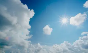 Błękitne niebo z białymi chmurami i słońcem. Idealna pogoda, by dowiedzieć się, kiedy najlepiej lecieć do Omanu.