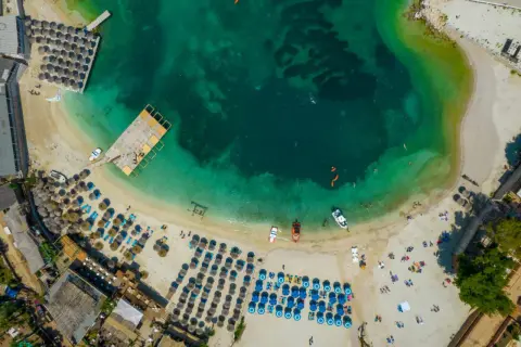 Piękna plaża z turkusową wodą i leżakami, idealne miejsce, gdzie jechać do Albanii na wakacje.