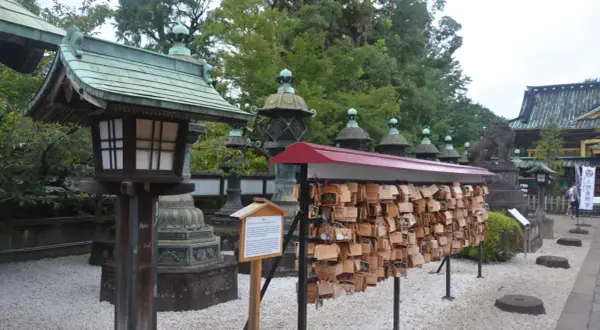 Tradycyjne latarnie i tabliczki z życzeniami w japońskiej świątyni. Warto zobaczyć w Japonii takie miejsca pełne kultury i spokoju.
